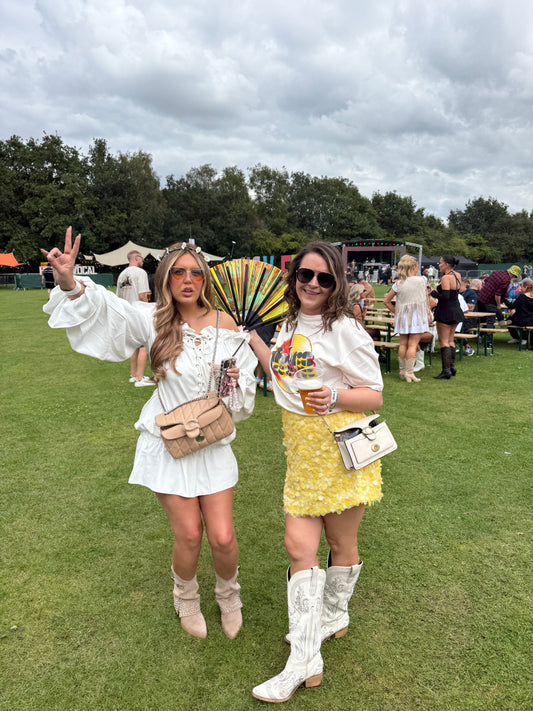 2 girls in a festival field wearing festival clothing