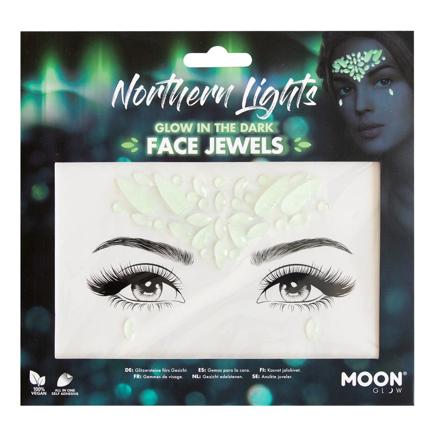 A package of 'Northern Lights Glow in the Dark Face Jewels' by Moon featuring adhesive face gems for a radiant look. The package is styled with an image of a person's face wearing the gems around the eyes and forehead, against a backdrop with a Northern Lights effect.