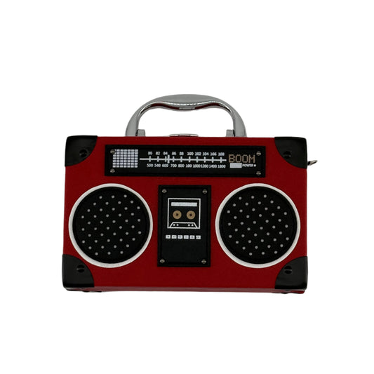 A red clutch bag designed to resemble a vintage radio with black speaker units and a silver handle.